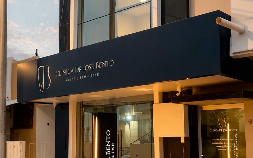 Fachada da Clínica Dr. José Bento ao entardecer, com marquise iluminada e letreiro vertical.