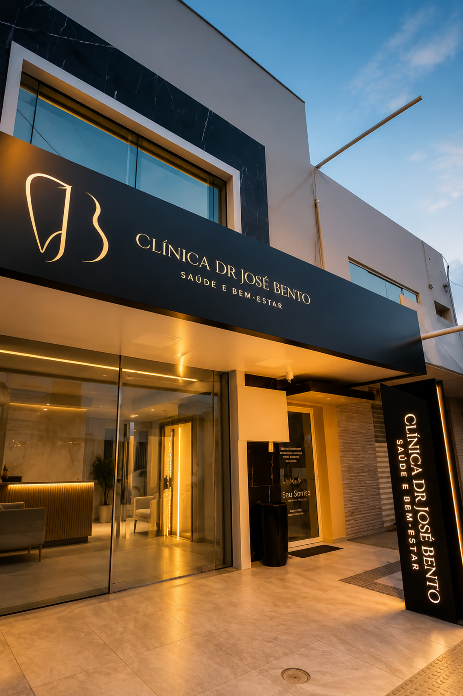 Entrada iluminada da Clínica Dr. José Bento à noite.